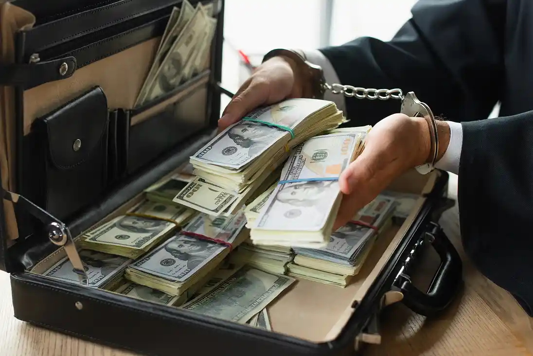 partial-view-of-businessman-in-handcuffs-holding-d-2026-01-05-23-44-56-utc 1